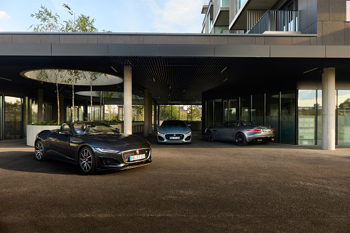 Three convertible Jaguars F type standing parked in front of a modern residential building First District. Katowice, June 17, 2022