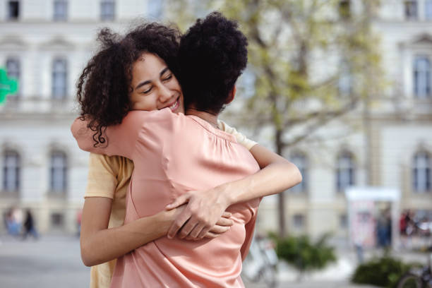 Business woman, hug and window with team applause for congratulations, thank you or farewell at office. Female person, colleagues or employees with smile for embrace, love or support at workplace