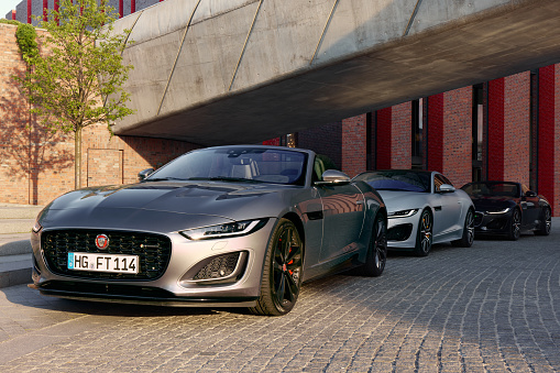 Three F-type Jaguars, cabriolets and coupe, standing in a row at the Katowice concert hall, June 17, 2022