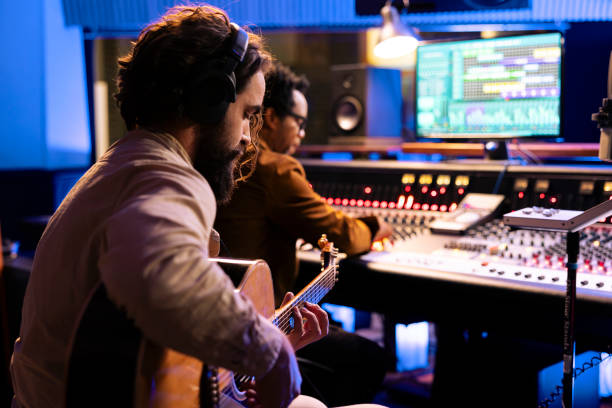 istock Artist playing a new record on his guitar in control room 2135068333