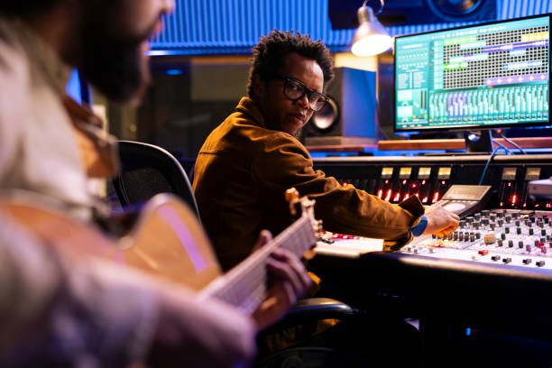istock Musician composing a new record with his guitar and mixing console in studio 2135071032