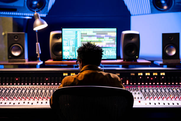 istock African american record producer editing and mixing tracks on audio console 2135073659
