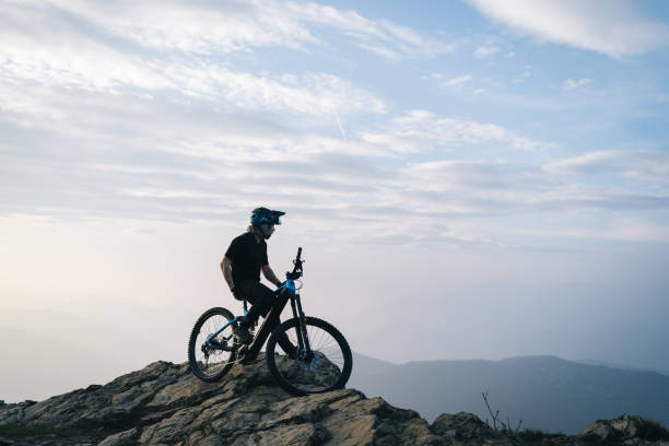 istock Male mountain biker pauses on mountain top 2135080019
