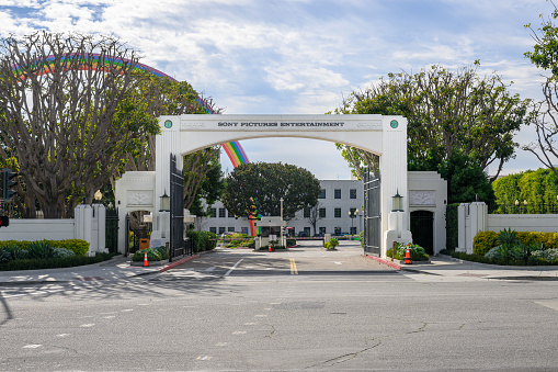 Culver City, United States – January 30, 2024: The entrance arch of Sony Pictures Entertainment with a colorful rainbow in the background