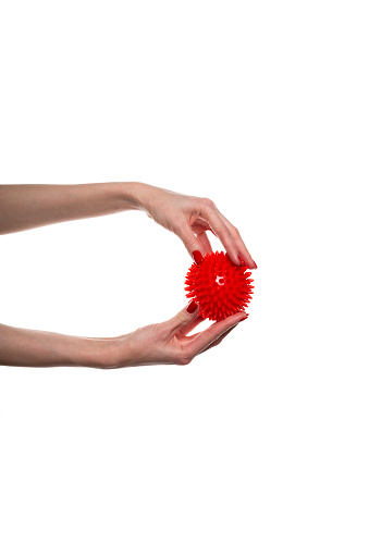 Massage red ball in female hand for trigger points isolated on a white background. Concept of myofascial release. High quality photo