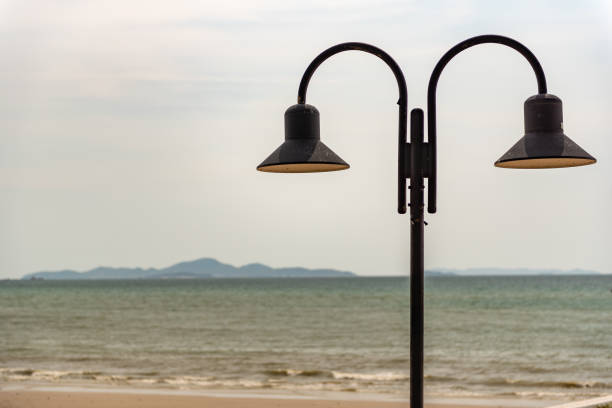 istock Vintage lamp post with calm water and grass nearby 2135108522