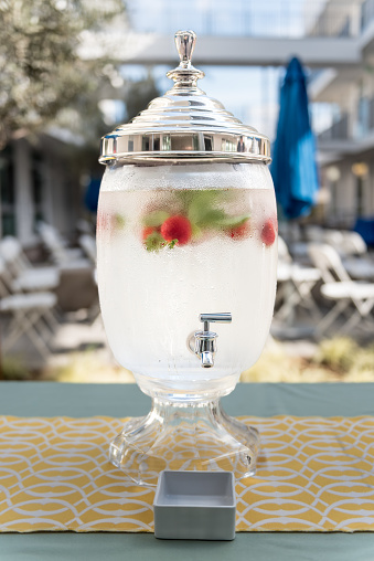 A strawberry-infused iced water in a glass water cooler