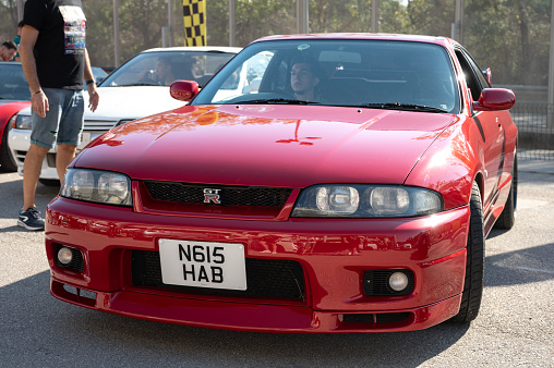 Montmelo, Spain – October 20, 2023: Front view of a red ninth-generation Nissan Skyline GT-R33 at a Japanese sports car meet.