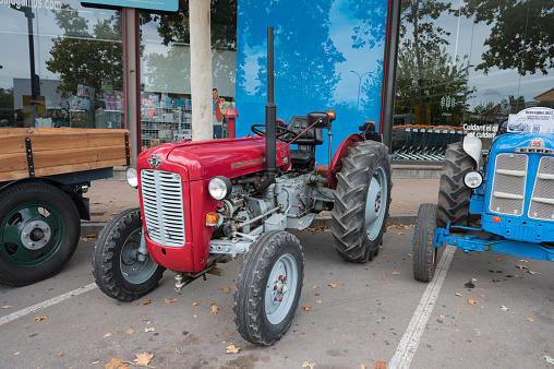 Caldes de Montbui, Spain – October 20, 2023: Front view of an old red tractor parked on the street, it is a Massey Ferguson model 35