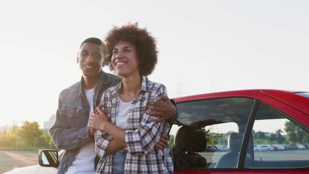 istock Happy couple hugging while standing near car outdoors. Slow motion 2135146203