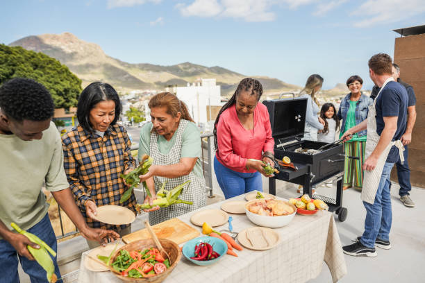 istock Multigenerational people doing barbecue at home's rooftop - Multiracial friends having fun eating and cooking together during weekend day - Summer and food concept - Main focus on asian woman face 2135186185