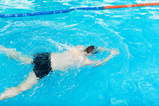 istock Young man swims in an indoor pool 2135229775