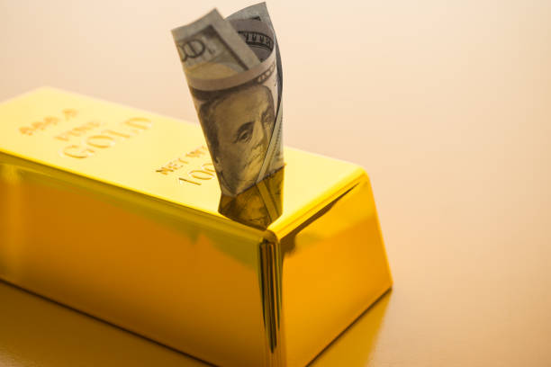 US dollar banknote savings insert in gold bar with copy space. Savings money in gold, investment by buying gold bar, etf, gold future concept. Gold is store of value in economy crisis and popular investment.