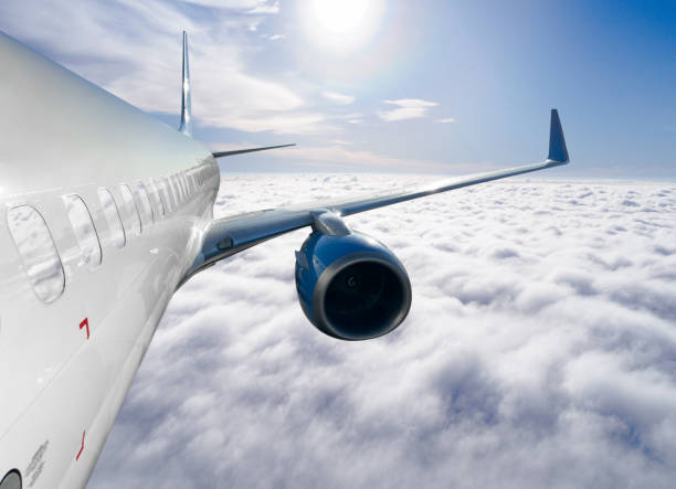 istock Passengers commercial airplane flying above clouds in sun light. Flying above clouds in dramatic sun light. Airplane in the sky. Detail of commercial jet airplane flying above clouds 2135274583