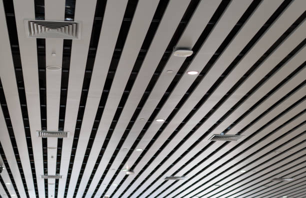 Lights and ventilation system in long line on ceiling of the industrial building. Exhibition Hall. Ceiling factory construction lights and ventilation system in long line on ceiling of the industrial building. exhibition hall. ceiling factory constructionlights and ventilation system in long line on ceiling of the industrial building. exhibition hall. ceiling factory constructio