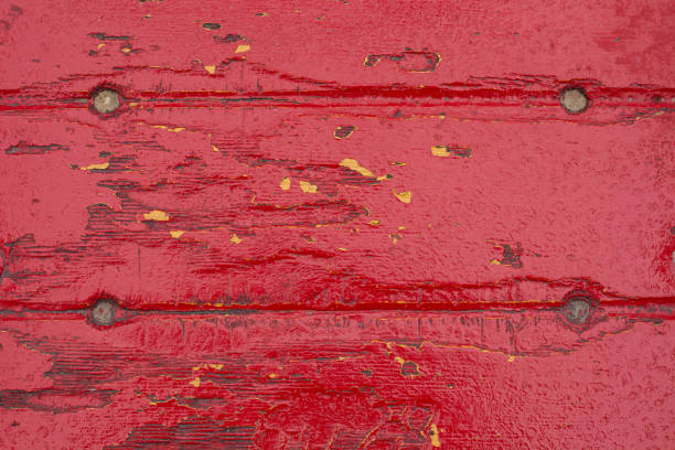 Wooden board long ago painted gray with yellow and red paint showing through