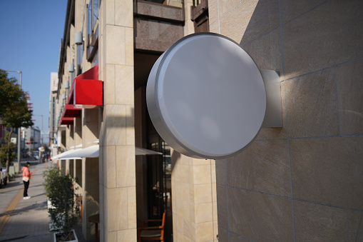 Blank White round signboard on the wall of a shopping center in the city.Mockup for design