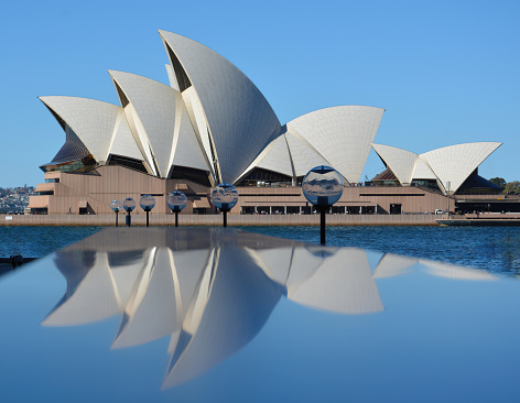 Sydney, Australia - July 31, 2014: Sydney Opera House reflected in the shiny surface of a lighting wall on the quayside in Sydney, Australia.