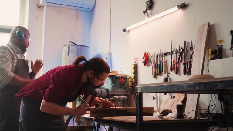 Woodworker using bench vise to hold lumber block, carving intricate designs