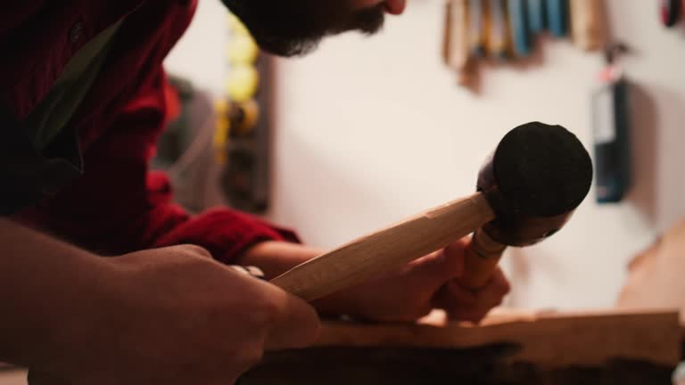 Artist uses vice tool to clamp piece of wood, shaping log