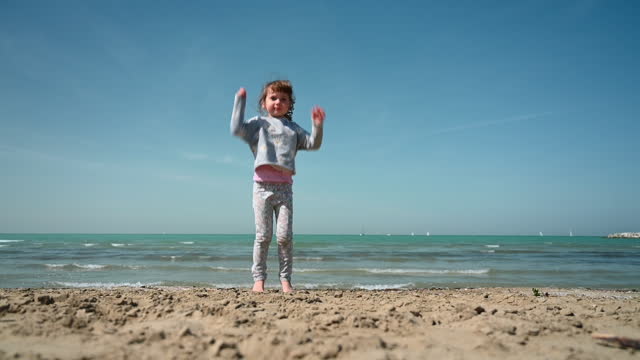 Little girl dancing on a Beach in springtime.
