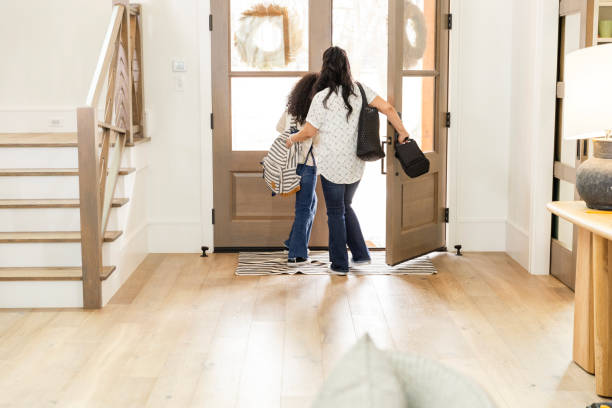 istock Mom opens front door and ushers young daughter out 2135381075