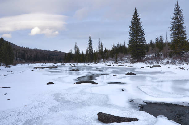 istock Icy river in a winter wonderland under a cloudy sky 2135417105