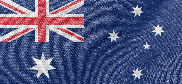 Small paper flag of Australia pinned. Isolated on white background. Horizontal orientation. Close up photography. Copy space.