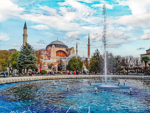 Istanbul, Turkey - October 28, 2019: Cityscape of Sultanahmet Square with a fountain against the backdrop of the Hagia Sophia in Istanbul. Famous tourist spot on autumn day