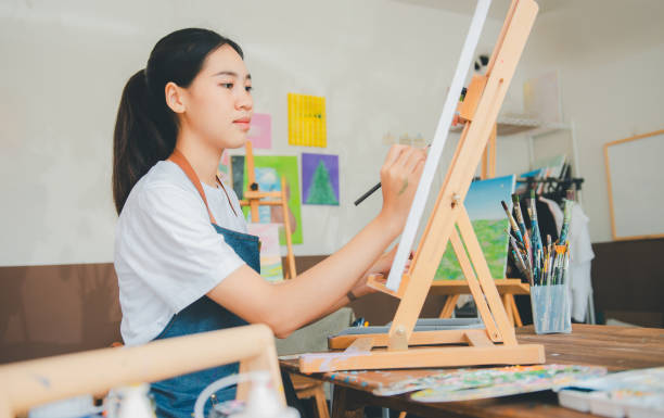 istock Art student drawing with watercolor painting on canvas doing some art projects on studio workshop 2135449780