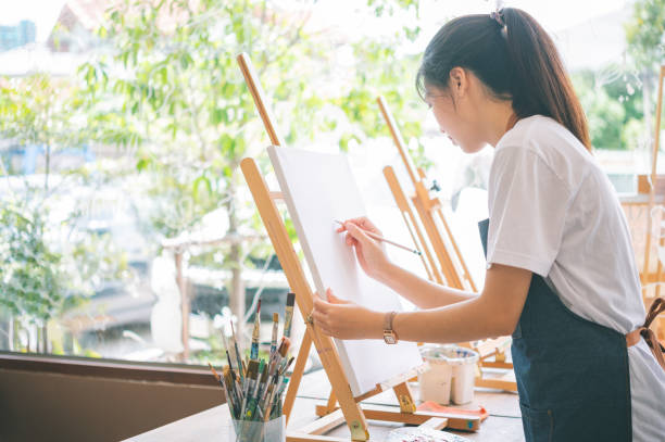 istock Art student drawing with watercolor painting on canvas doing some art projects on studio workshop 2135452012