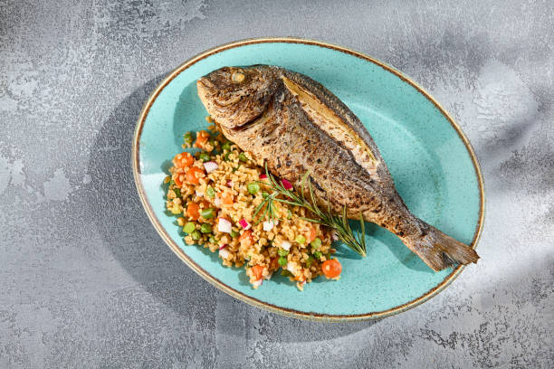 Grilled Dorado over Bulgur and Vegetable Medley Elegantly Presented on a Textured Plate