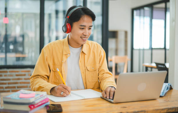 istock Young Asian college student working and learning on laptop In the cafe. Searching for knowledge online. 2135457437