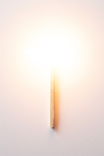A lit match on a sheet of paper.
