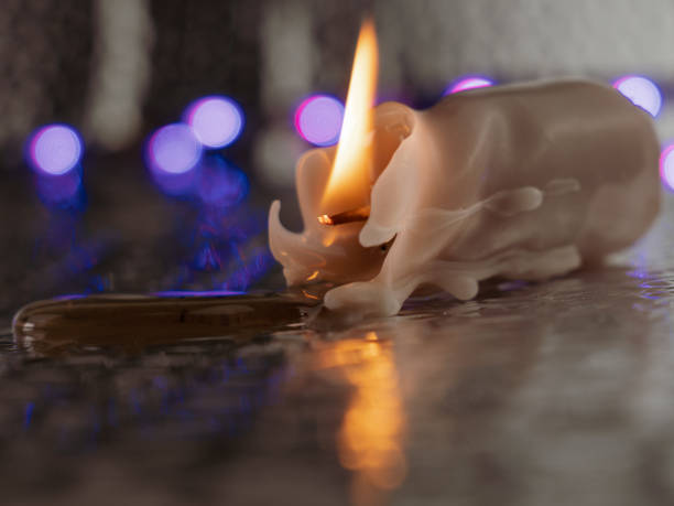 A lit candle in a candle holder on a table