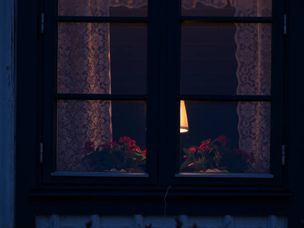 istock Small candle sits on a windowsill next to a curtain 2135507648