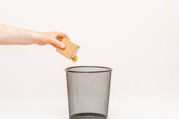 istock The small gift paper box is thrown into the dustbin,can for disposal and recycling.White,gray background,selective focus,copy space. 2135520712