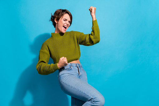 Photo of positive cheerful girl wear trendy clothes scream win lottery jackpot isolated on cyan color background.