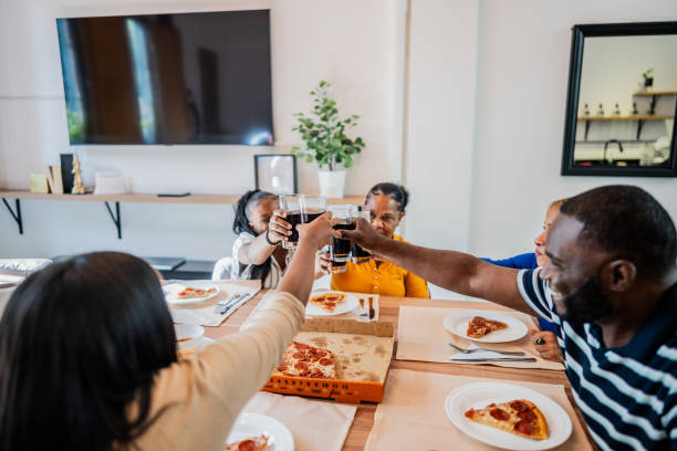 istock Family toasting with soda while eating pizza at home 2135522415
