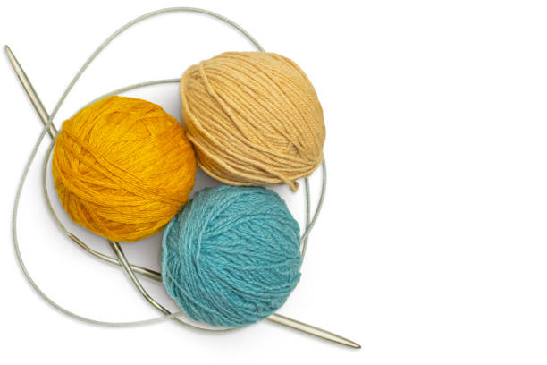 Wool with knitting needles on white.
