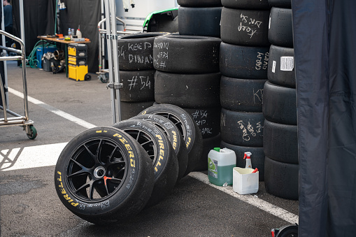 Montmelo, Spain – October 20, 2023: Detail of the Pirelli PZero slick tire stacks. marked with notes with white chalk and a bottle of water with a cabon to clean them