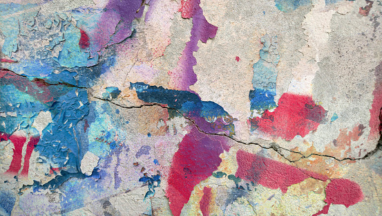 High resolution old weathered polychrome concrete wall detail, coated with multiple layers of various paints, applied through the years randomly one on top of the other, slowly cracking and peeling off, run down by the elements, high resolution grunge background texture stock photo.