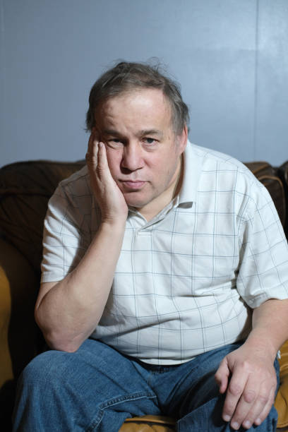 Ragged and dirty homeless man with nowhere to go and nothing to do. Posed by model.