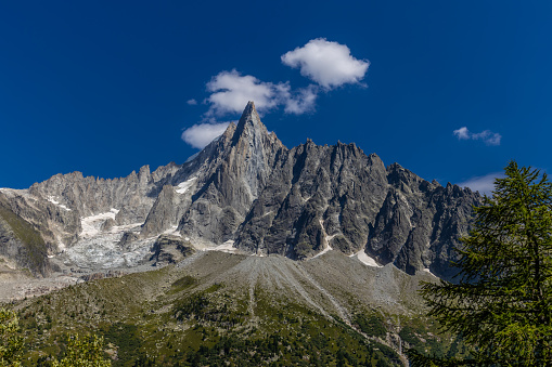 Tour du Montblanc beautiful mountain peaks and green valley. TMB trekking route scenic landscape in Alps in Chamonix valley alpine scene. Aiguilles du Chamonix, Aiguille du Dru, Petit Dru