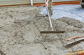 An employee of construction company uses a special tool to level concrete