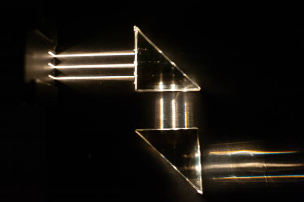 Light beams reflect against mirrored triangles, simulating the operation of a periscope in a submarine. Demonstration test in physics class under dark conditions.