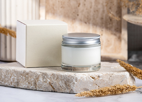 Two jars of natural cosmetic product on linen fabric