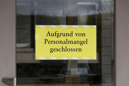 Information sign in German: Aufgrund von Personalmangel geschlossen (Closed due to staff shortages)