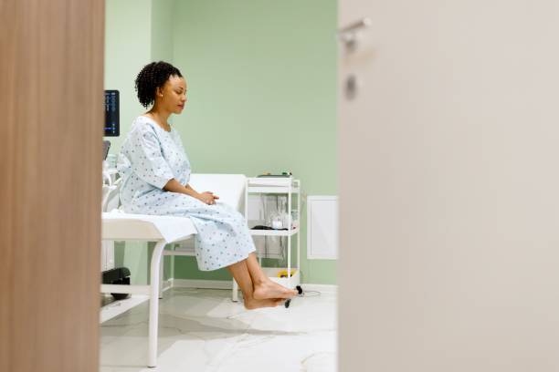Side view of a woman sitting on exam table.