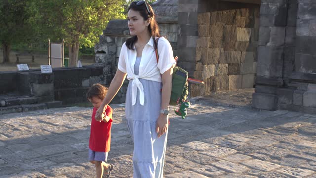 Chinese mother holding her son hand when climbing stair on  Ratu Boko Temple, Yogyakarta